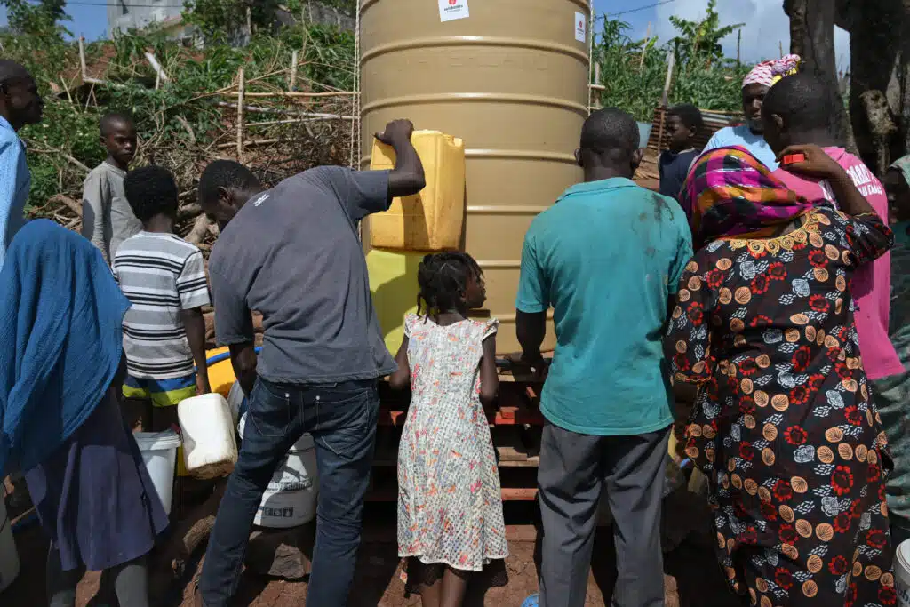Les habitants du bidonville viennent remplir leurs bidons avec l’eau potable ramenée par la Croix Rouge. Les premiers sont arrivés tôt le matin plusieurs heures avant l’arrivée du camion.