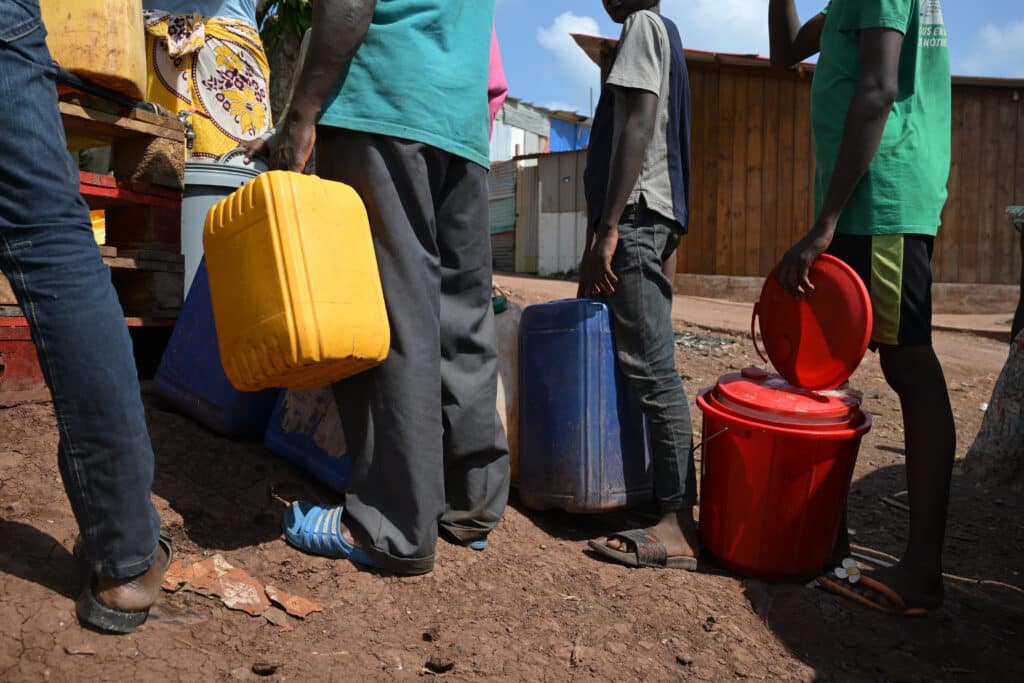 Habitants attendant leur tour pour récupérer de l’eau potable. Les solutions de stockage sont très précaires alors que celle-ci n'est parfois utilisée que plusieurs jours après.