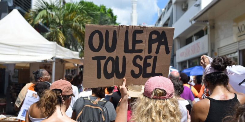 Une manifestante tient une pancarte sur laquelle on peut lire 