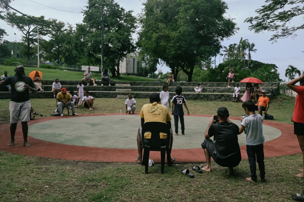 Trois arbitres notent les points alors que les premiers combattants se présentent au milieu du rond.