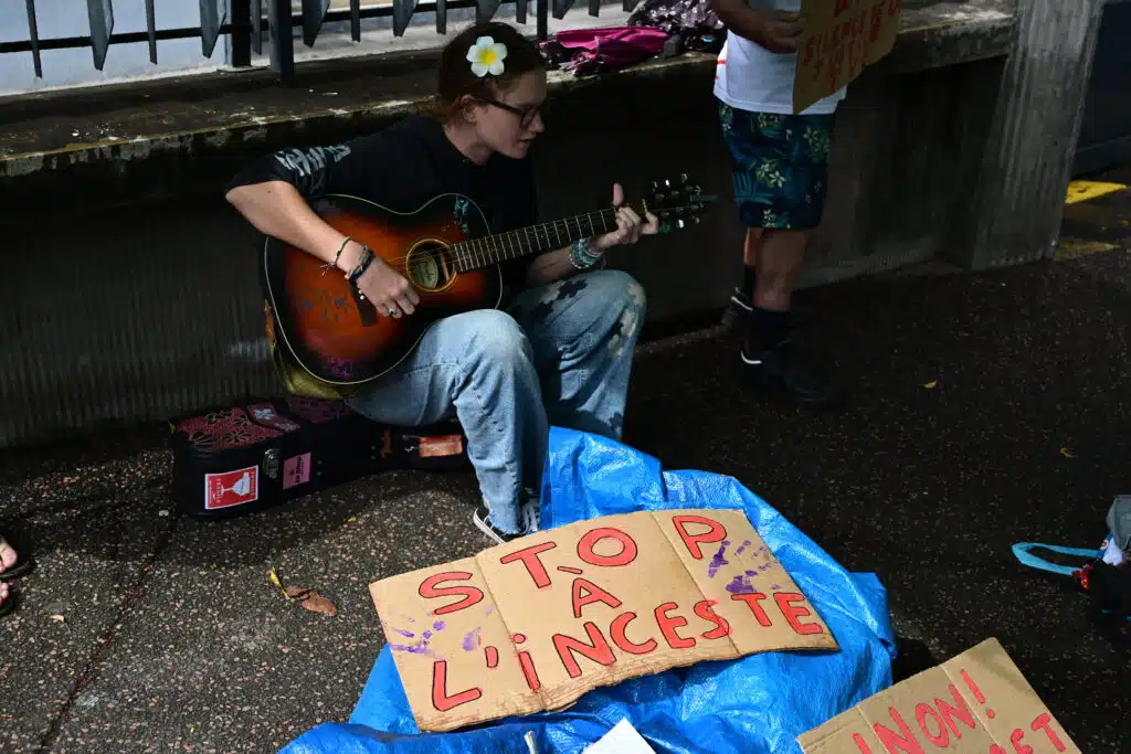Prune, de l'association Mon pt'i Loup interprète plusieurs morceaux à la guitare pour évoquer les violences envers les enfants.