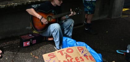 Prune, de l'association Mon pt'i Loup interprète plusieurs morceaux à la guitare pour évoquer les violences envers les enfants.