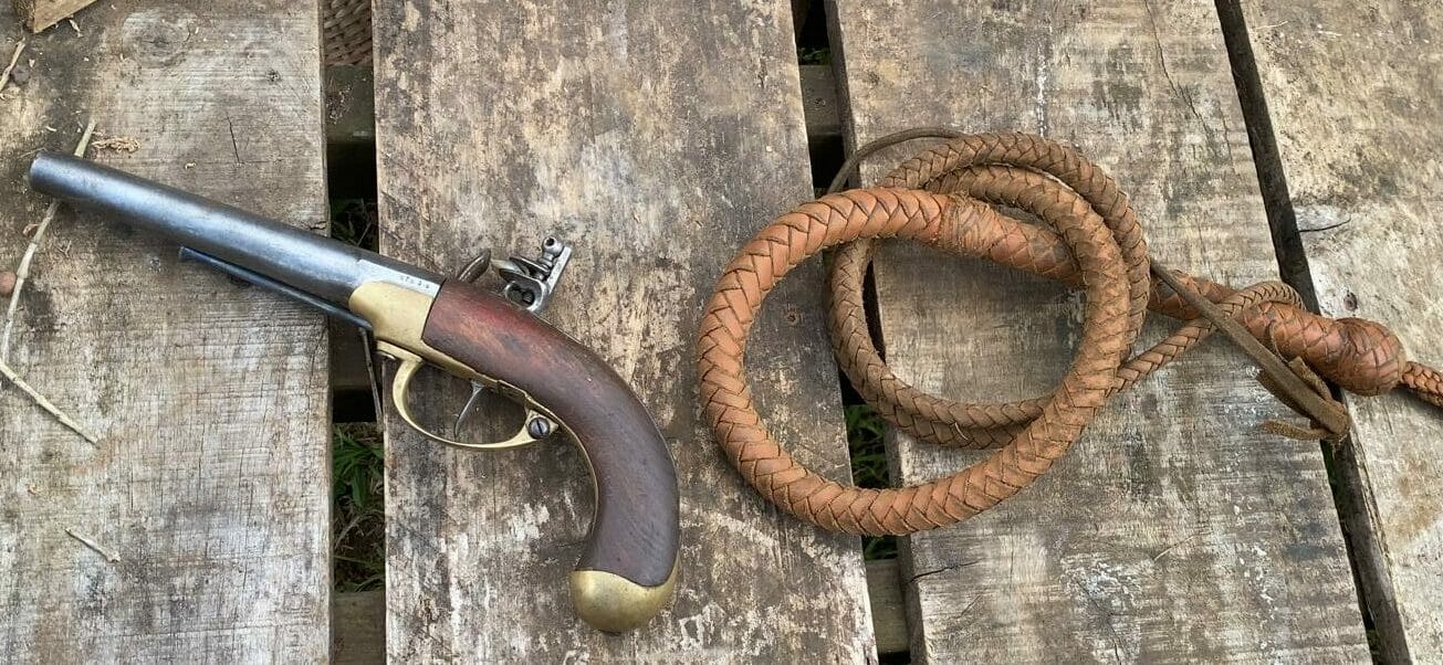 Pistolet non rechargé et fouet d’époque, instruments de violence utilisés durant la traite transatlantique.