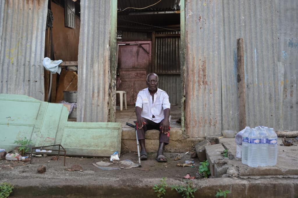 Un homme se tient devant sa maison ravagée par le passage de la tempête Dikeledi dans le Sud de Mayotte.