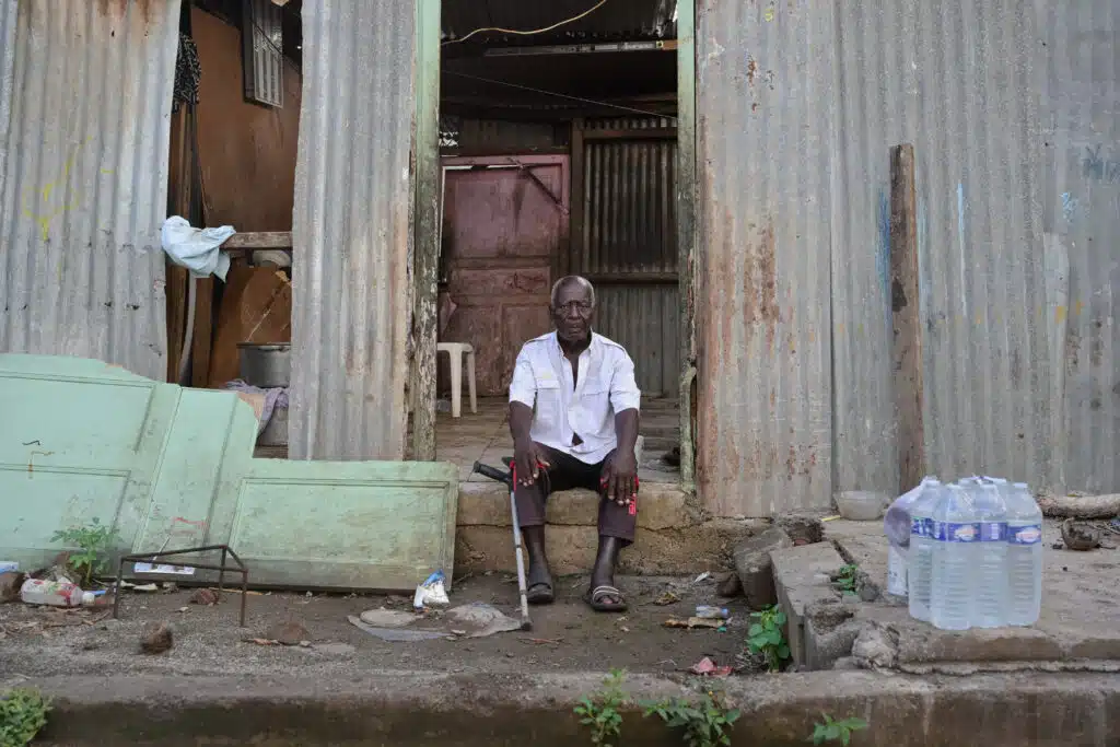 Un homme se tient devant sa maison ravagée par le passage de la tempête Dikeledi dans le Sud de Mayotte.