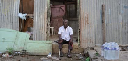 Un homme se tient devant sa maison ravagée par le passage de la tempête Dikeledi dans le Sud de Mayotte.