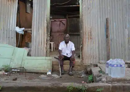 Un homme se tient devant sa maison ravagée par le passage de la tempête Dikeledi dans le Sud de Mayotte.