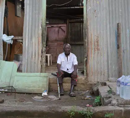 Un homme se tient devant sa maison ravagée par le passage de la tempête Dikeledi dans le Sud de Mayotte.