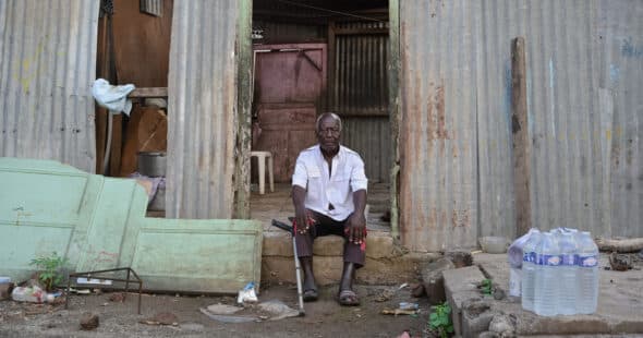 Un homme se tient devant sa maison ravagée par le passage de la tempête Dikeledi dans le Sud de Mayotte.