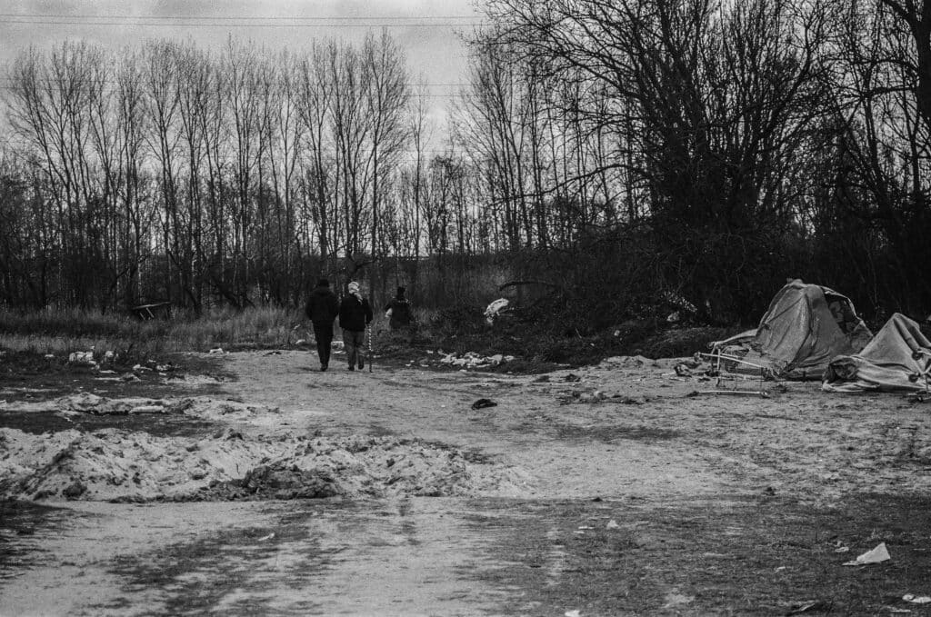 Deux hommes retournent à leur tente sur le campement de personnes exilées de Grande-Synthe.