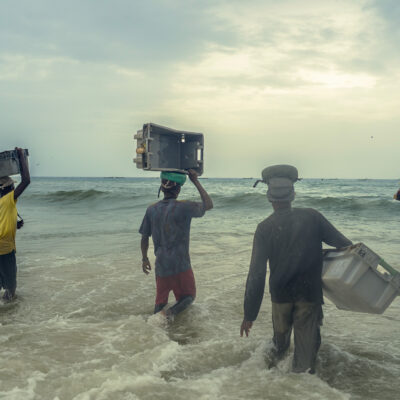 Les hommes se pressent pour aller récupérer les poissons. Il faut aller vite car les bateaux ne s'arrêtent que quelques minutes avant de repartir en mer.